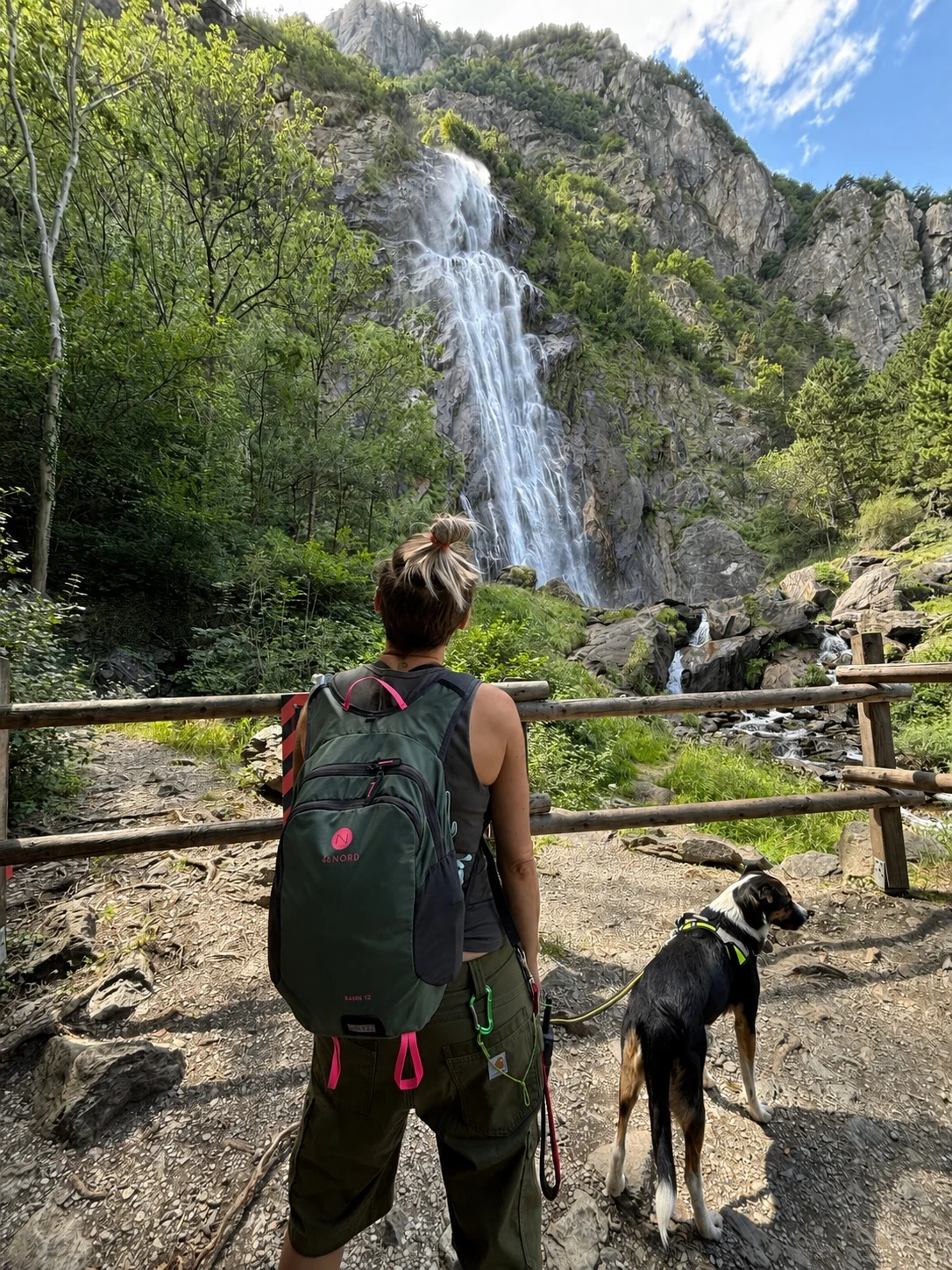 Promeneuse Wouf & Go avec un chien devant une cascade valaisanne